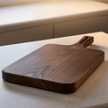 Dark walnut charcuterie serving board angled view showing hardwood thickness and rounded edges
