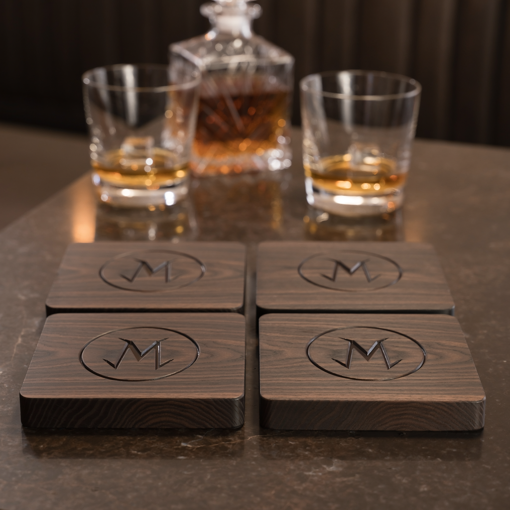 Matching set of four dark walnut M monogram coasters styled on a refined home bar