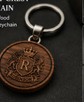 Personalized family crest keychain with engraved round wood medallion, leather connector and metal key ring