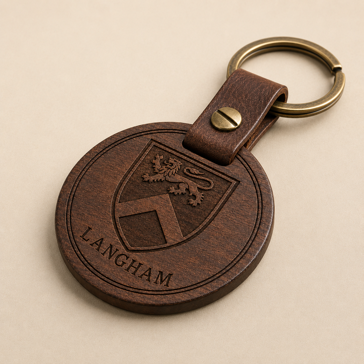 Side profile of engraved dark walnut family crest keychain showing wood edge, leather connector and brass hardware