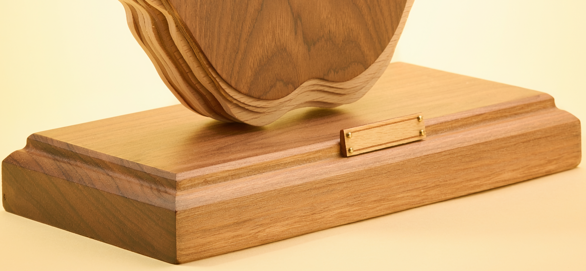 Close-up of the blank personalization plate and finished wood base on the teacher appreciation desk heirloom