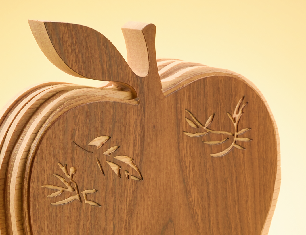 Close-up of the solid layered apple form and engraved leaf detail on the teacher appreciation desk heirloom